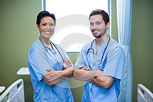 Portrait of male and female nurse standing in ward