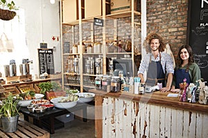 Portrait Of Male And Female Owners Of Sustainable Plastic Free Grocery Store Behind Sales Desk