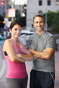 Portrait Of Male And Female Runners On Urban Street