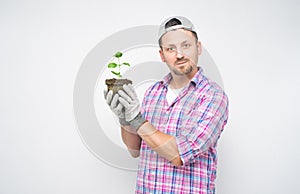 Portrait of male gardener with plant in soil. Plant care concept, isolated on white background. Male farmer