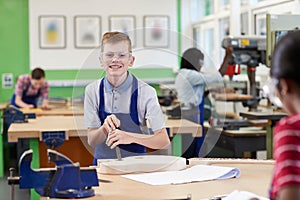 Portrait Of Male High School Student Building Guitar In Woodwork