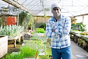 Portrait of male hired worker in greenhouse where flowers are grown