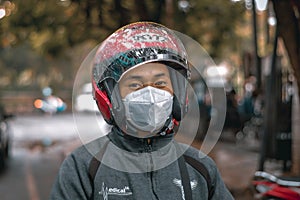 A portrait of a male hospital nurse riding a motorcycle preparing to leave after the morning shift