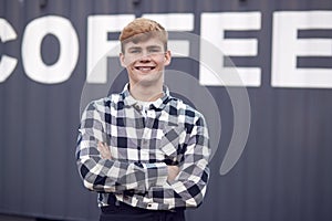 Portrait Of Male Intern At Freight Haulage Business Standing By Shipping Container 