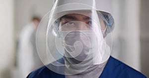 Portrait of male medical doctor wearing protective mask and face shield