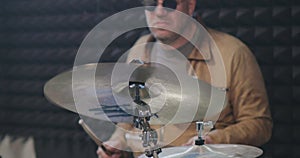 Portrait of male middle-aged drummer hitting cymbals