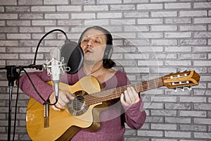 Portrait of male musician who sings song into microphone. Studio shot.