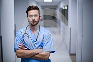 Portrait of male nurse standing in corridor