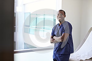 Portrait Of Male Nurse Wearing Scrubs In Exam Room photo