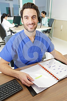 portrait male nurse working at nurses station