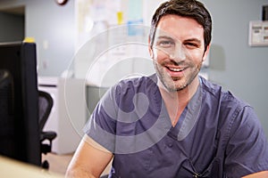 Portrait Of Male Nurse Working At Nurses Station photo