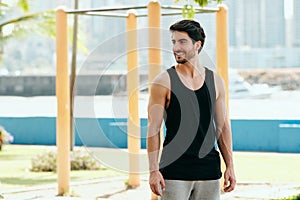 Portrait of Male Personal Trainer Working Out In City Park