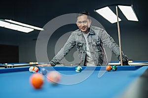 portrait of the male pool player seriously observing the billiard balls