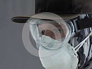 Portrait of a male on protective face mask and goggles. People protect from Covid-19