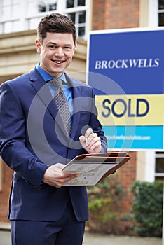 Portrait Of Male Realtor Standing Outside Residential Property photo