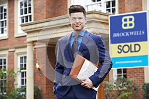 Portrait Of Male Realtor Standing Outside Residential Property