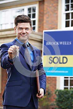 Portrait Of Male Realtor Standing Outside Residential Property H