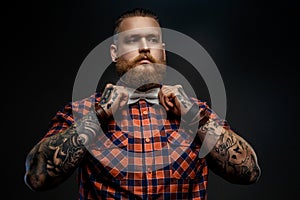 Portrait of male in red shirt and grey bow tie.