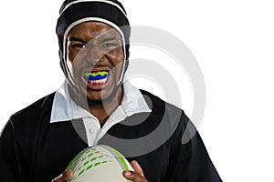 Portrait of male rugby player wearing mouthguard white holding rugby ball