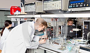 Portrait of male scientist registering results of research in notebook at biochemical laboratory