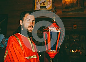 Portrait of a male Sexton in a red dress with a red lantern photo