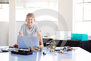 Portrait Of Male Student Building And Programing Robot Vehicle In School Computer Coding Class photo