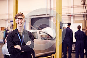 Portrait Of Male Student Wearing Safety Glasses Studying For Auto Mechanic Apprenticeship At College
