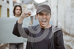 Portrait male students holding blank paper who are burning with enthusiasm