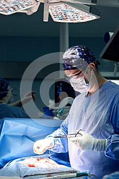 Portrait of a male surgeon in the operating room on the background of modern surgery and lighting devices, a modern