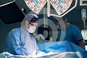 Portrait of a male surgeon in the operating room on the background of modern surgery and lighting devices, a modern