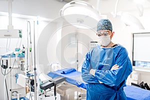 Portrait of male surgeon in operating room with surgery lights on and medical devices. Modern hospital details