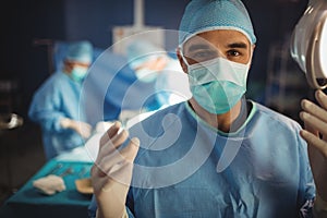 Portrait of male surgeon preparing for operation in operation room