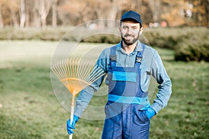 Portrait of a male sweeper with rakes outdoors