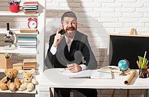 Portrait of male teacher from preschool or elementary school in class. Teacher having idea. Amazed teacher waiting for