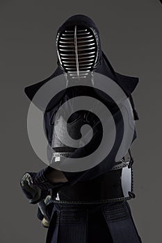 Portrait of male in tradition kendo armor with bamboo sword