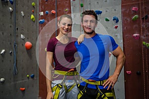 Portrait of male trainer with athelte against climbing wall