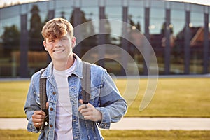 Portrait Of Male University Or College Student Standing Outdoors By Modern Campus Building