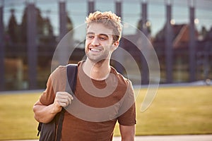 Portrait Of Male University Or College Student Standing Outdoors By Modern Campus Building