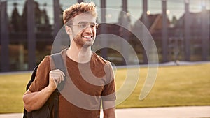 Portrait Of Male University Or College Student Standing Outdoors By Modern Campus Building