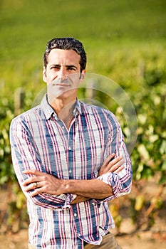 Portrait of male vintner standing with arms crossed