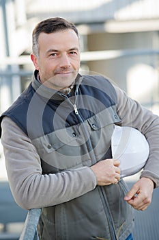 portrait male worker outdoors holding hardhat