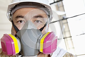 Portrait of male worker wearing dust mask at construction site