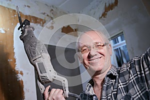Portrait of a man 55-60 years old in a working environment during the repair of an apartment with his own hands, in a