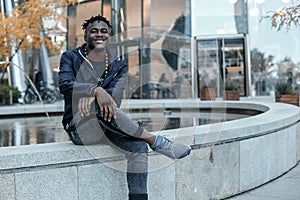 Portrait man African American attractive profile in the street. Fashion african man wearing jeans jacket poses on city. african