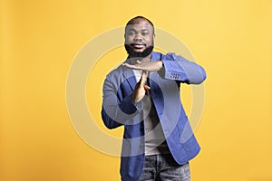 Portrait of man asking for timeout, doing hand gestures, studio background