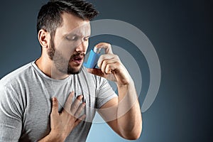 Portrait of a man with an asthma inhaler in his hands, an asthmatic attack. The concept of treatment of bronchial asthma, cough,