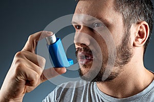 Portrait of a man with an asthma inhaler in his hands, an asthmatic attack. The concept of treatment of bronchial asthma, cough,