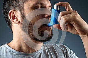 Portrait of a man with an asthma inhaler in his hands, an asthmatic attack. The concept of treatment of bronchial asthma, cough, photo