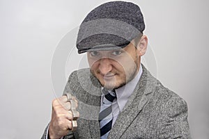 Portrait of a man in a boxing stance with brass knuckles, causing serious bodily harm, a threat to life and health.