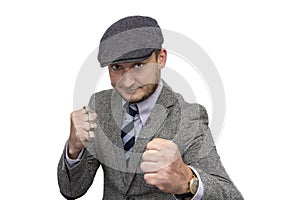 Portrait of a man in a boxing stance with brass knuckles in his hand on a white background.The concept:a blow that causes serious